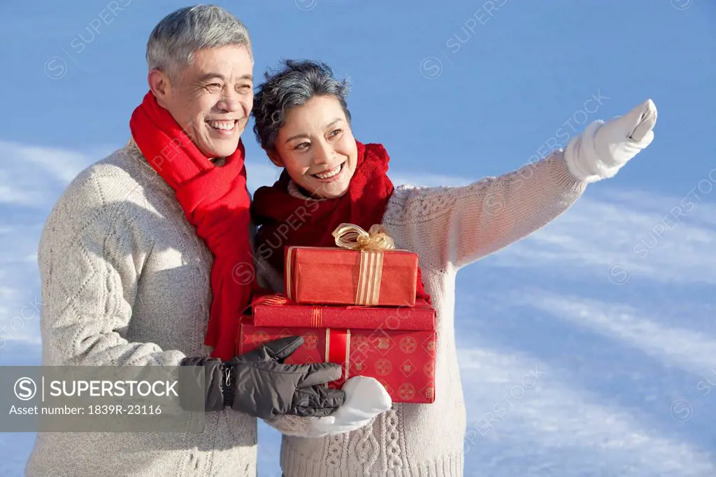 Senior couple holding gift boxes