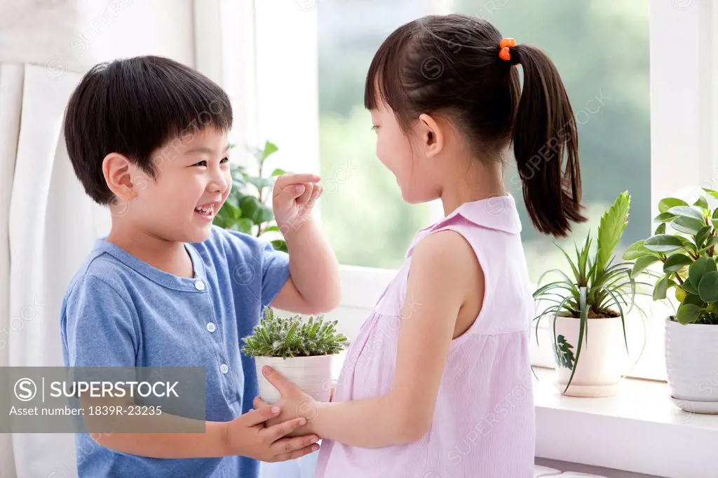 Boy and girl holding the potted plants