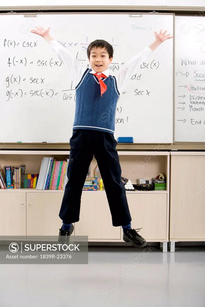 Young student jumping in front of whiteboard