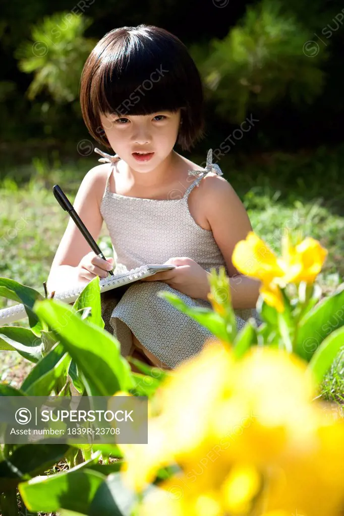 Little girl painting in garden