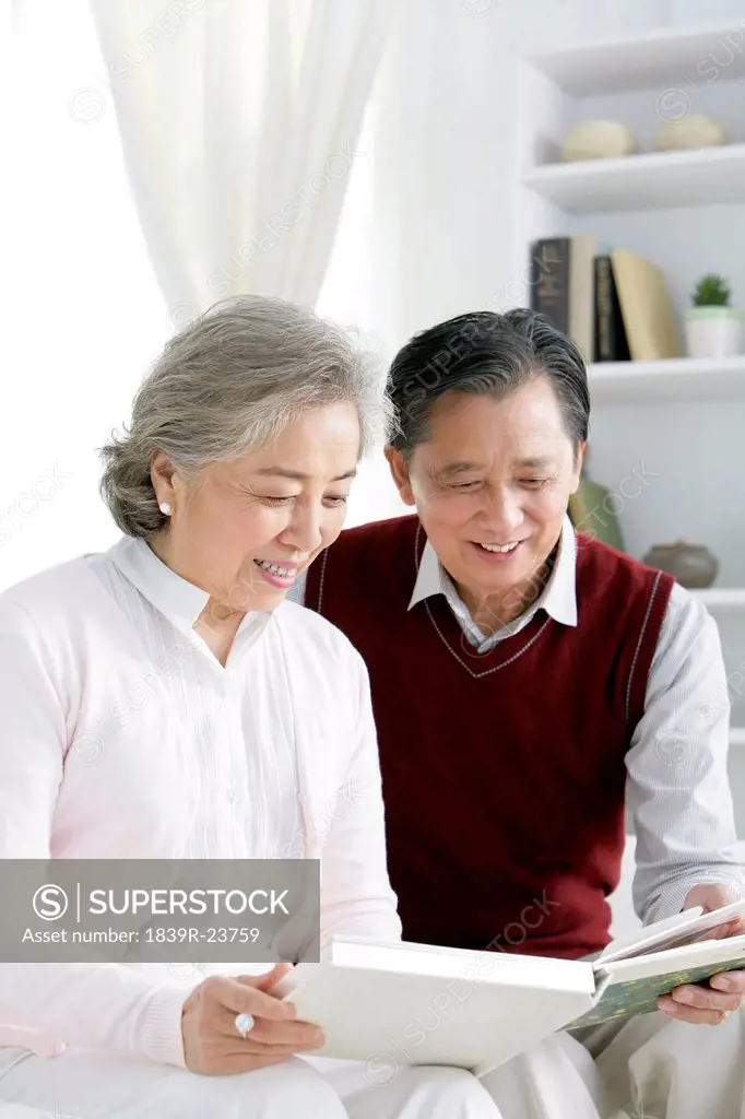 Senior Chinese couple looking at photo album