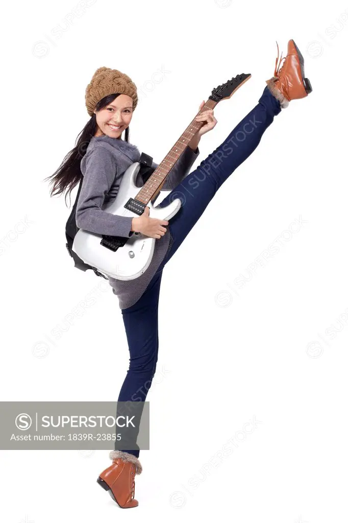 Stylish young woman playing guitar