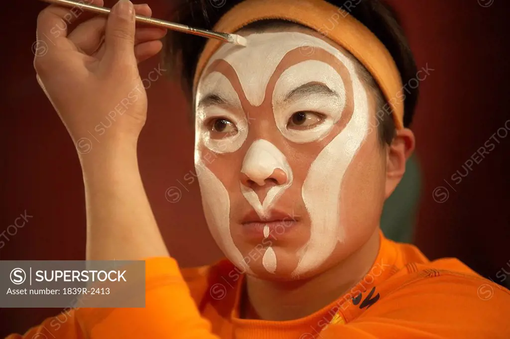 Performer Applying Face Paint With Brush