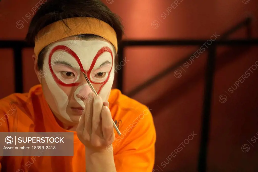 Performer Applying Face Paint With Brush