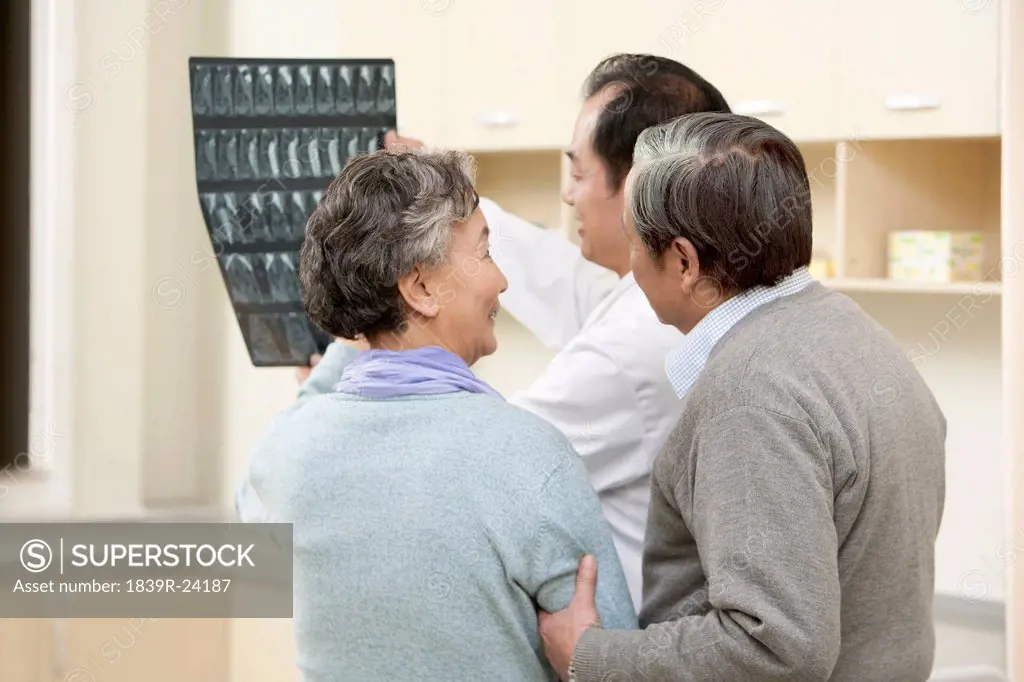 Doctor Shows an X_Ray Test Results to Senior Couple