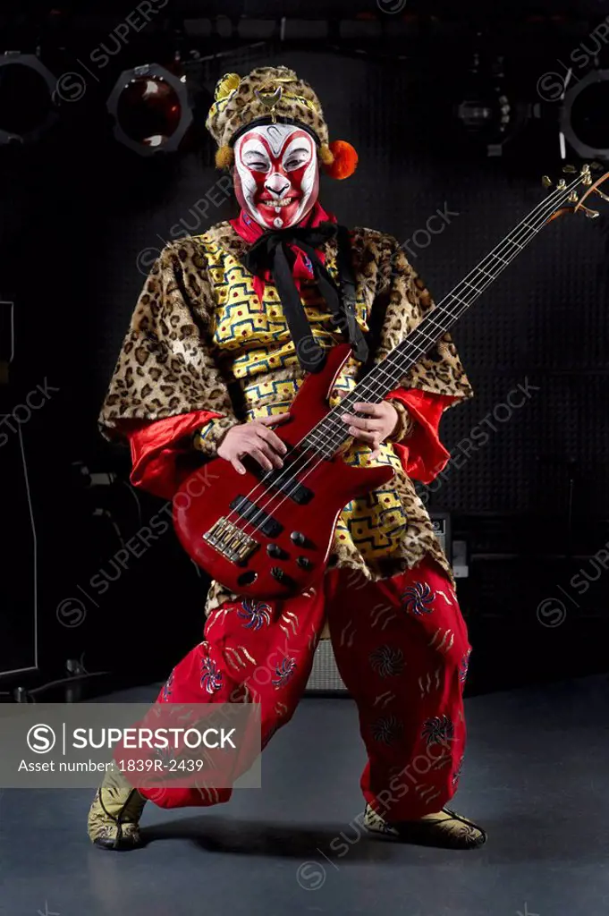 Man In Ceremonial Costume Playing The Electric Guitar
