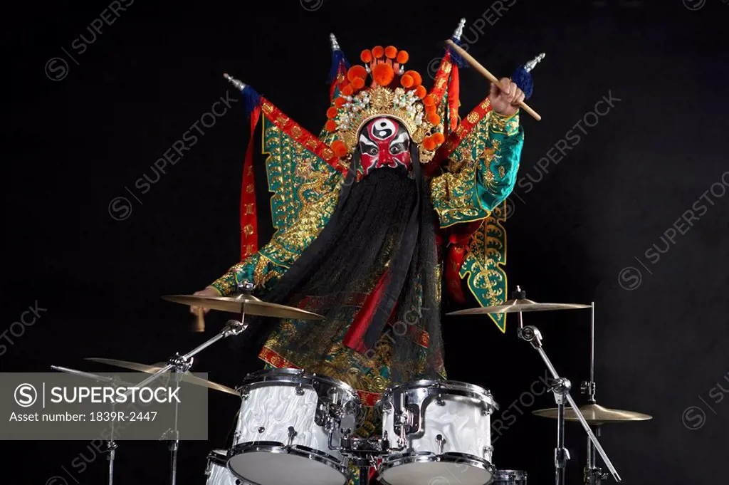 Man In Ceremonial Costume Playing The Drums