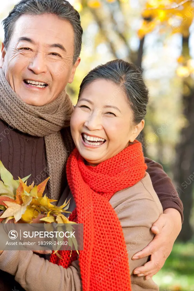 Senior couple with a collection of leaves in Autumn