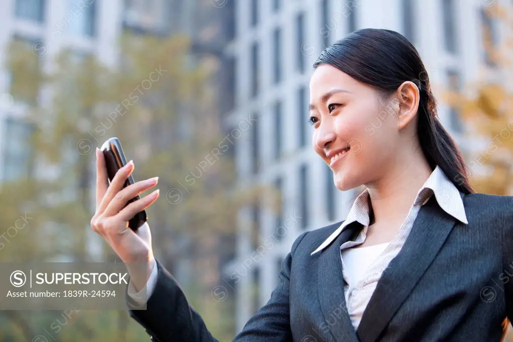 Businesswoman outside office buildings on her mobile phone