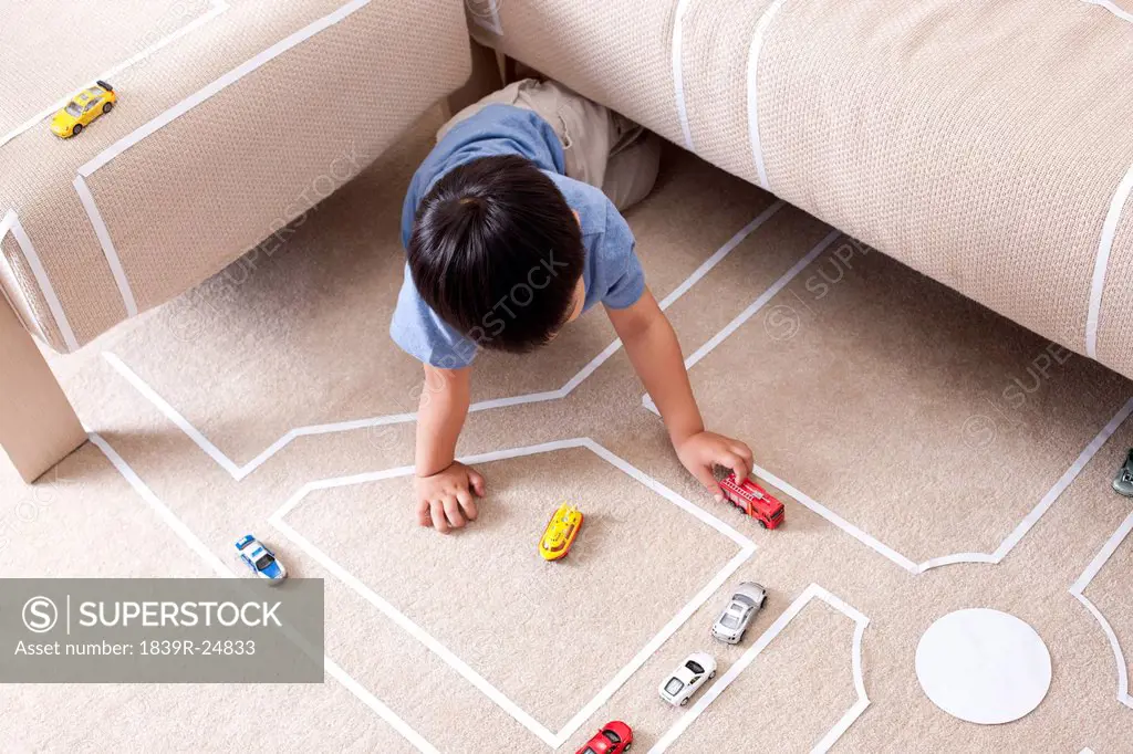 Boy playing toy car at home