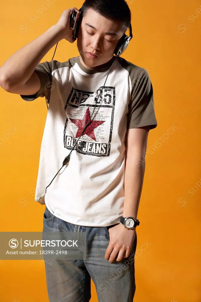 Teenager With Headphones On Listening To Music