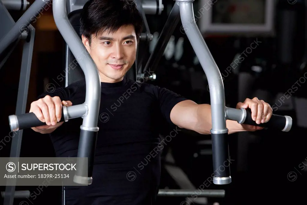Young Man Using Exercise Machine