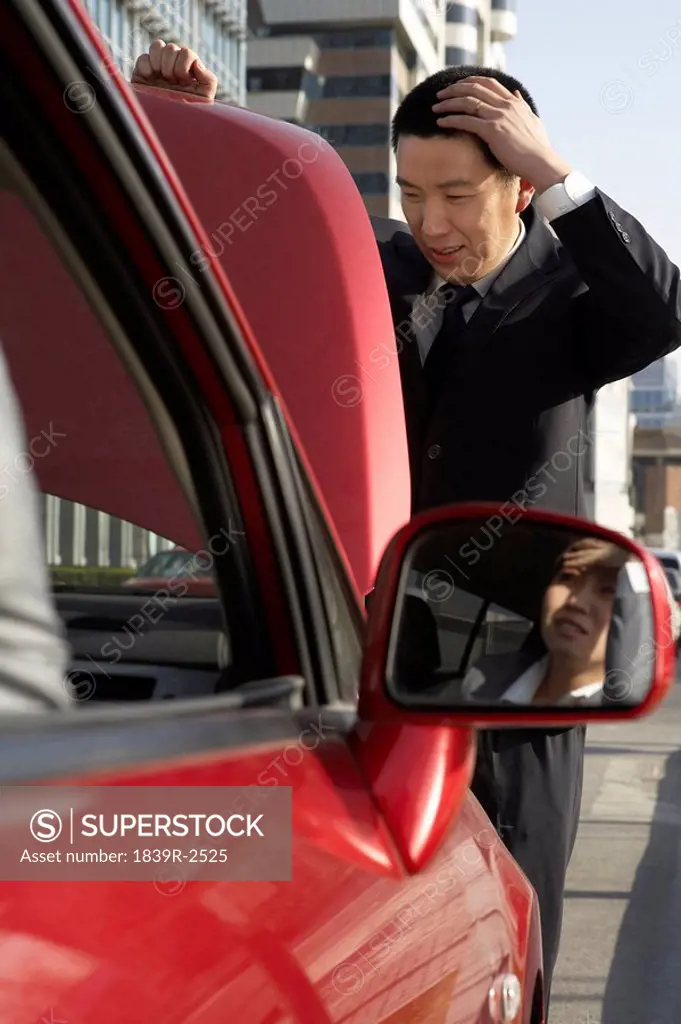 Businessman Trying To Fix Car