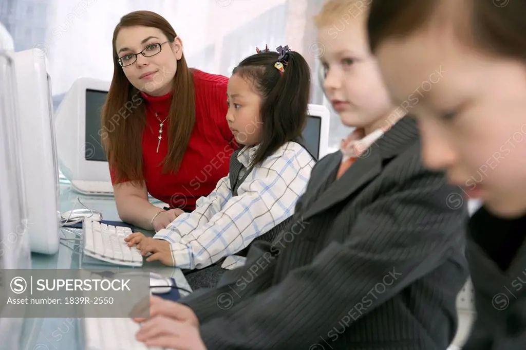 Teacher Watching Children Using Computers