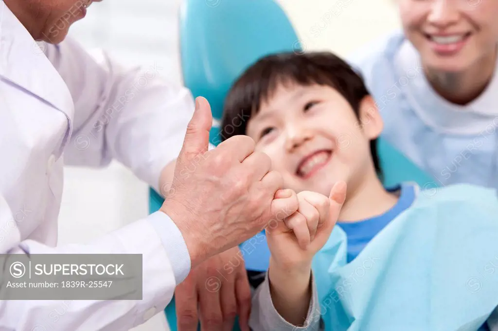 Dentist making promise with a little patient