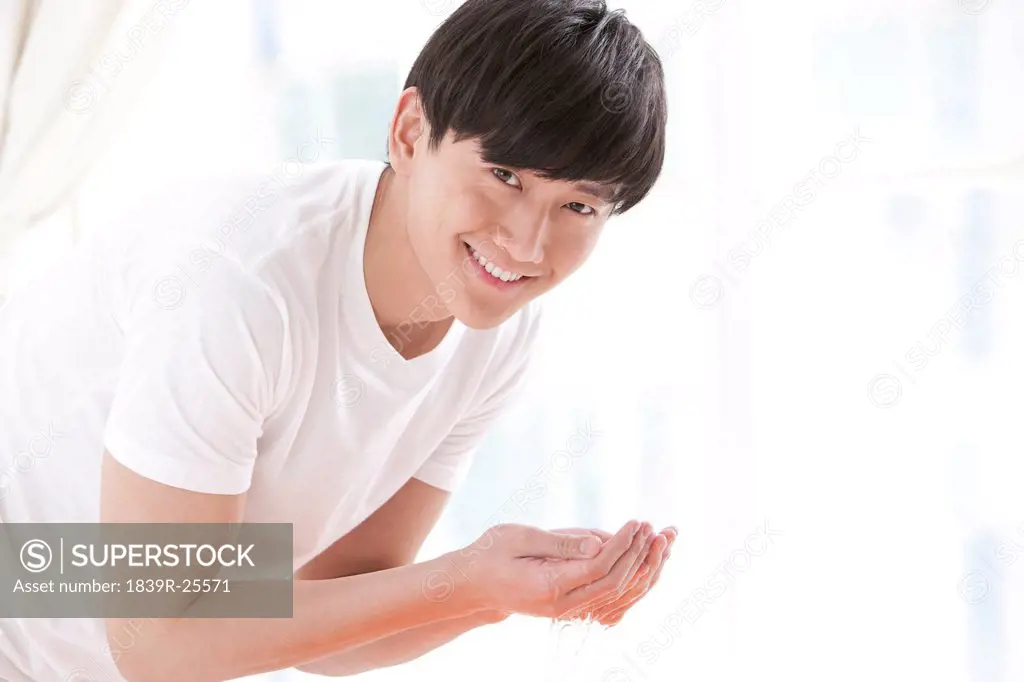 Young man washing face