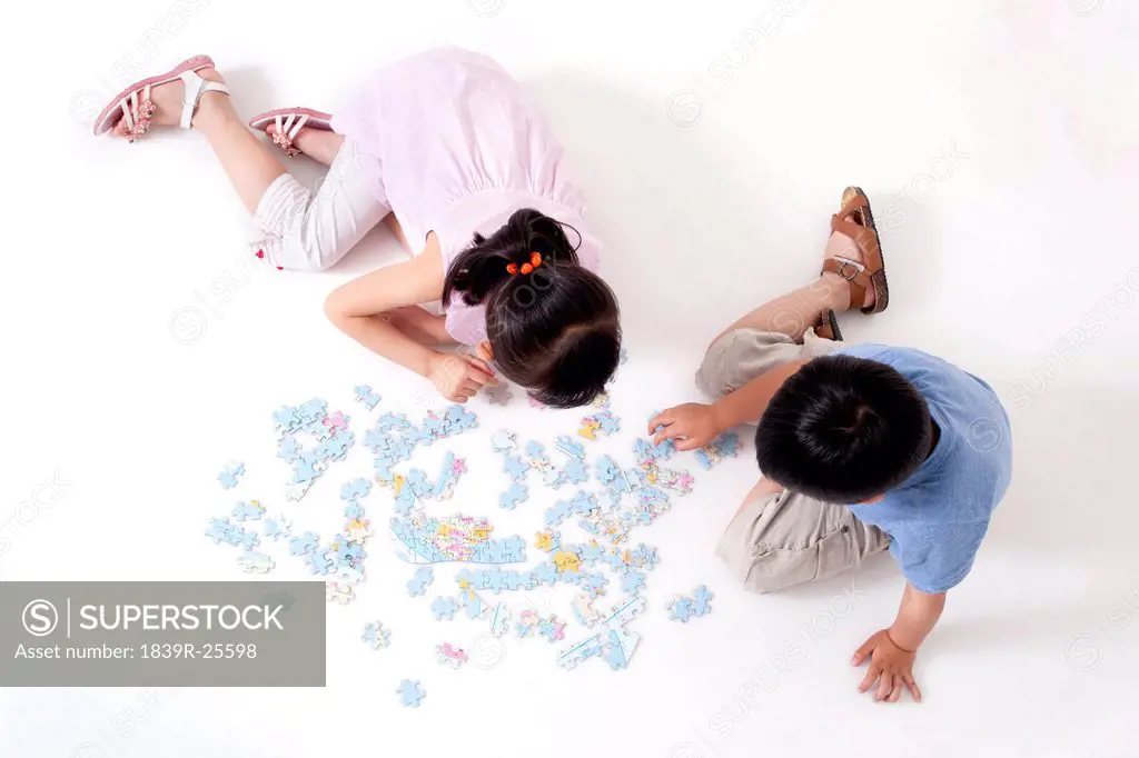 Boy and girl playing jigsaw puzzles together