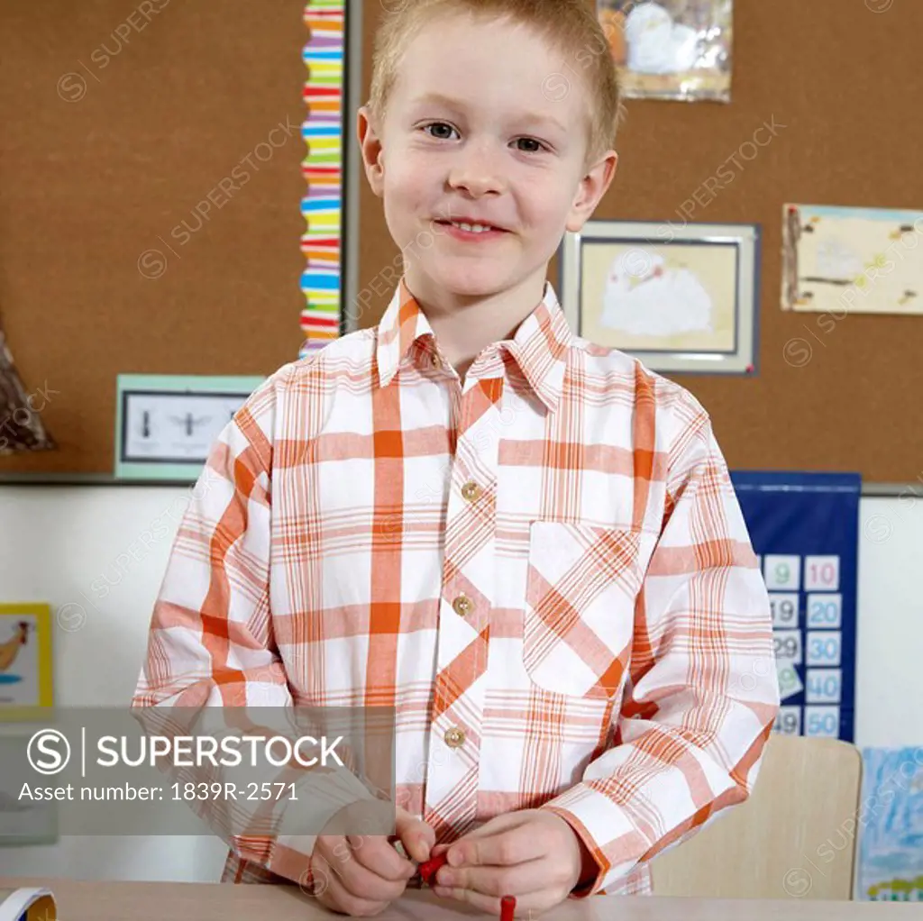 Boy Sitting At Desk, Smiling