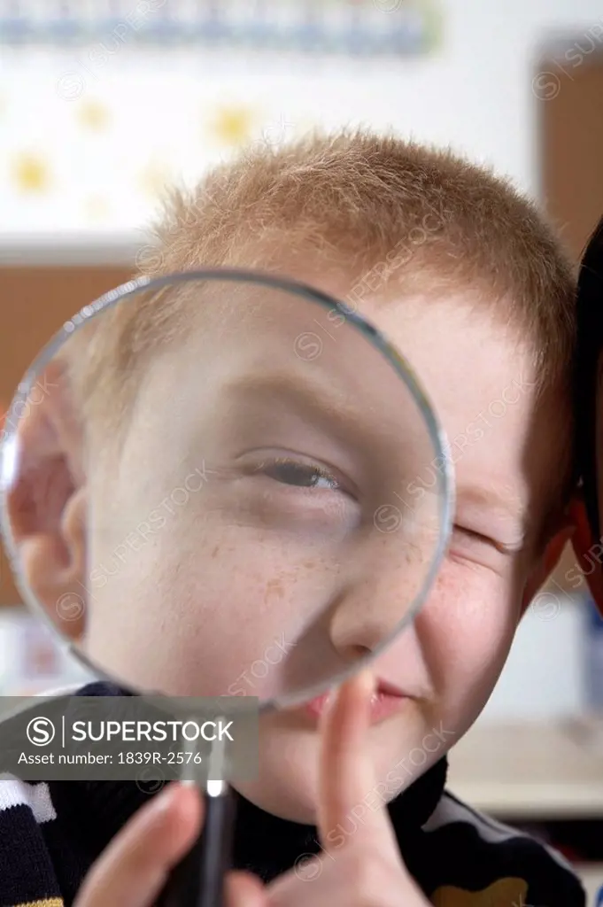 Boy Looking Through Magnifying Glass