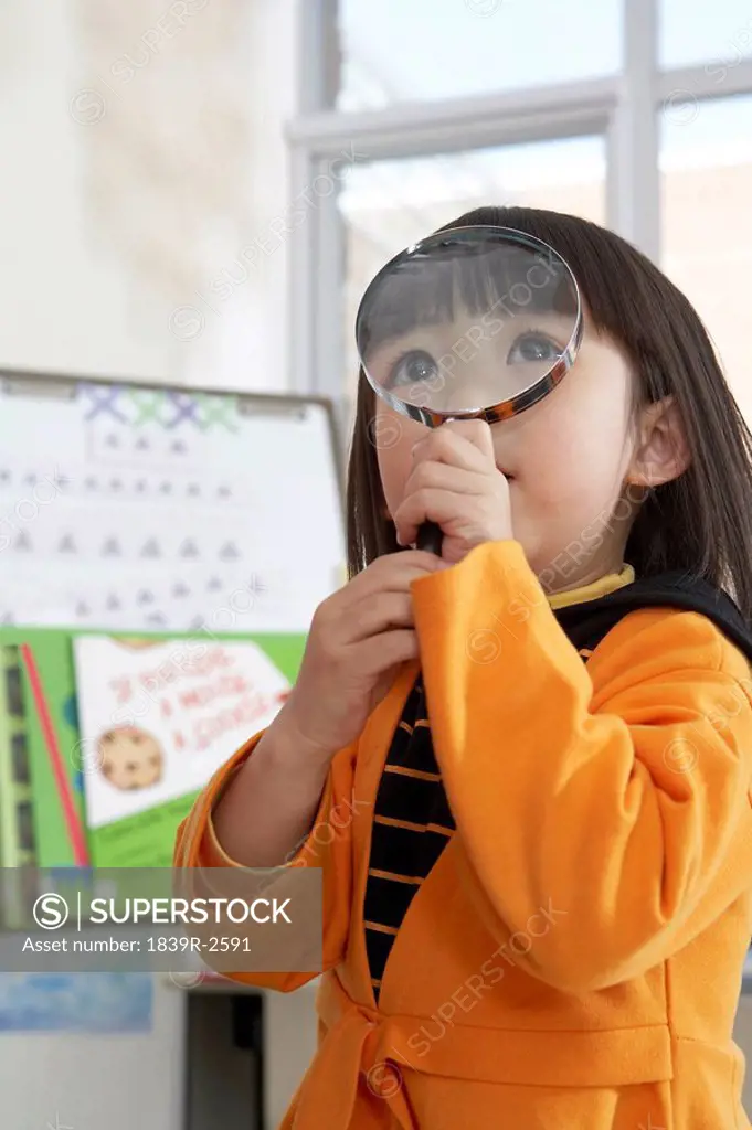 Small Girl Looking Through Magnifying Glass