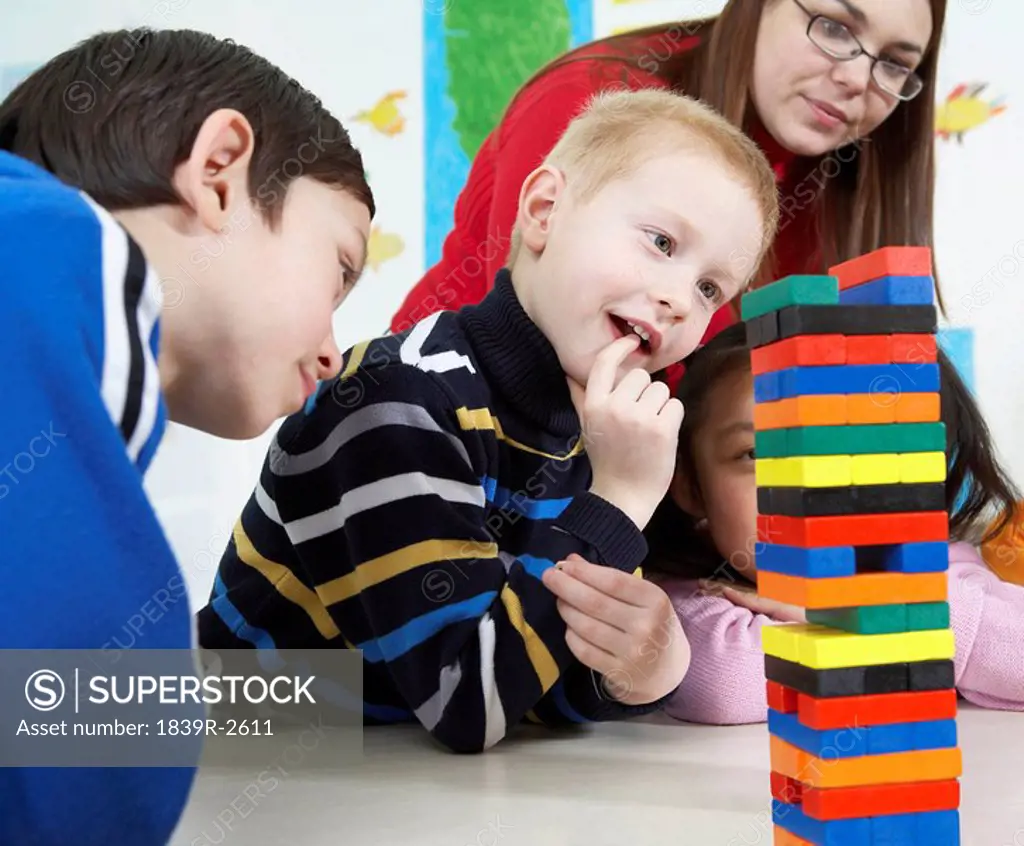 Children Looking At Tower Of Blocks