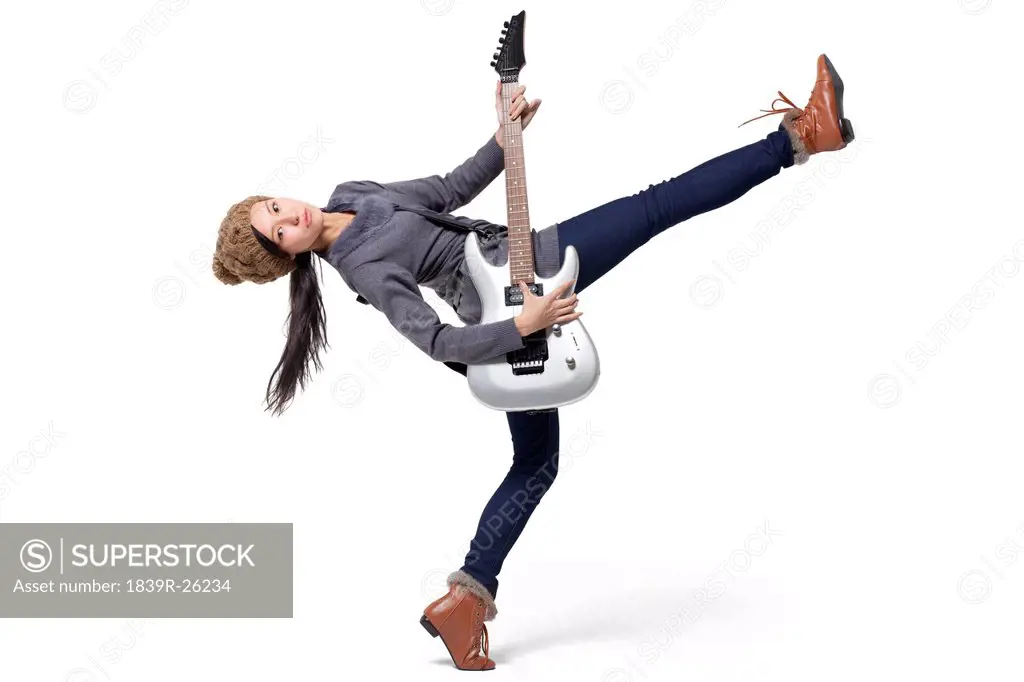 Stylish young woman playing guitar