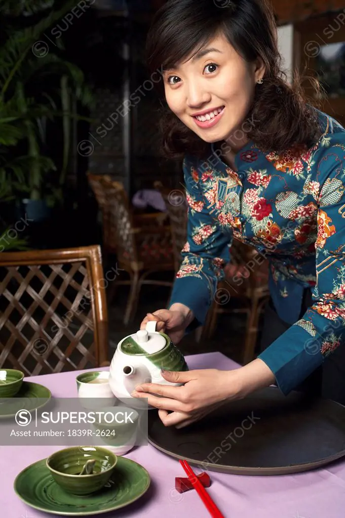 Waitress Pouring Cup Of Tea