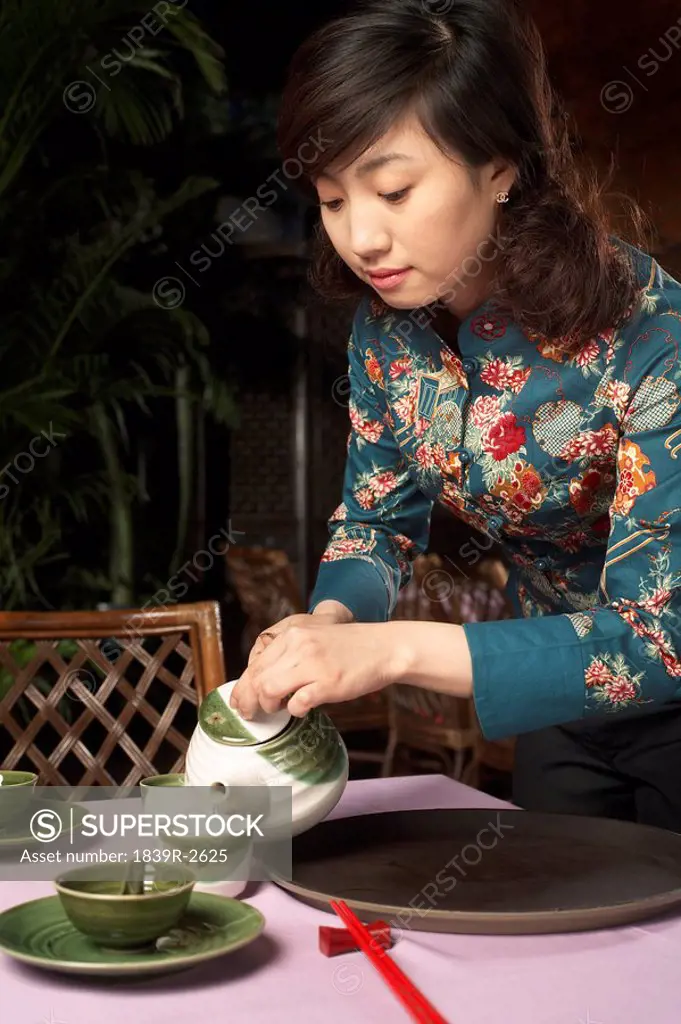 Waitress Pouring Cup Of Tea