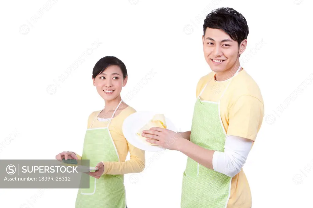 Young couple cleaning plates
