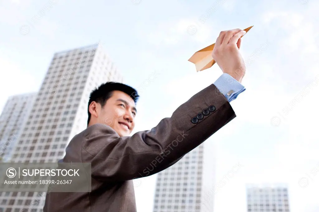 Young businessman and paper plane