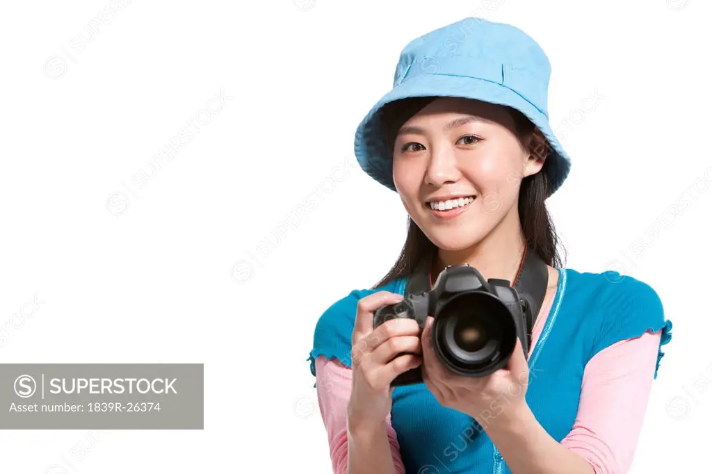 Portrait of a young woman holding a camera