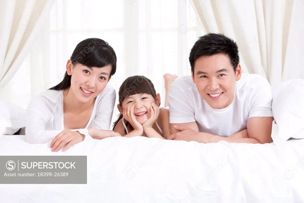 Happy family lying in bed
