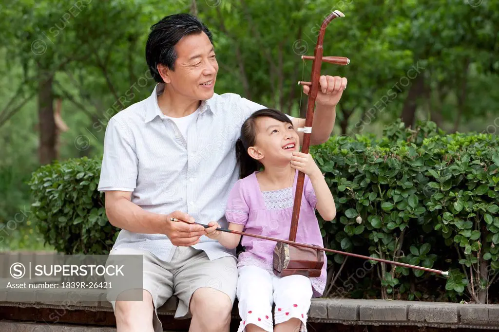 Grandfather teaching Chinese traditional musical instrument Erhu