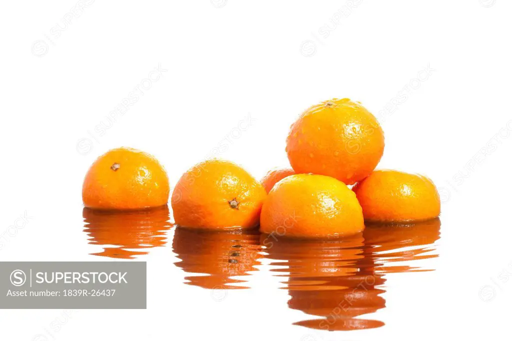 Oranges with reflection on rippling water surface