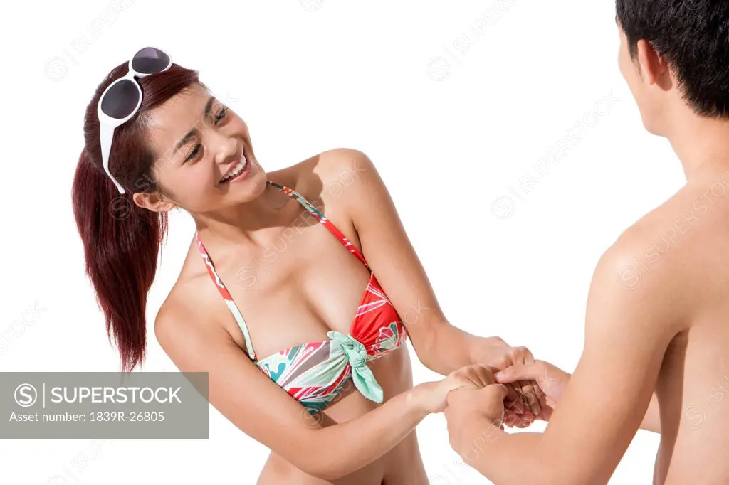 Young man and young woman in swimsuit having fun
