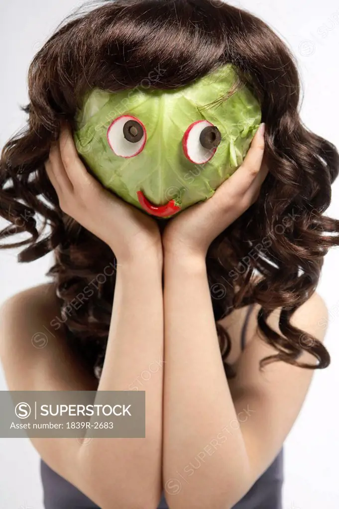 Women Covering Face With Cabbage Mask