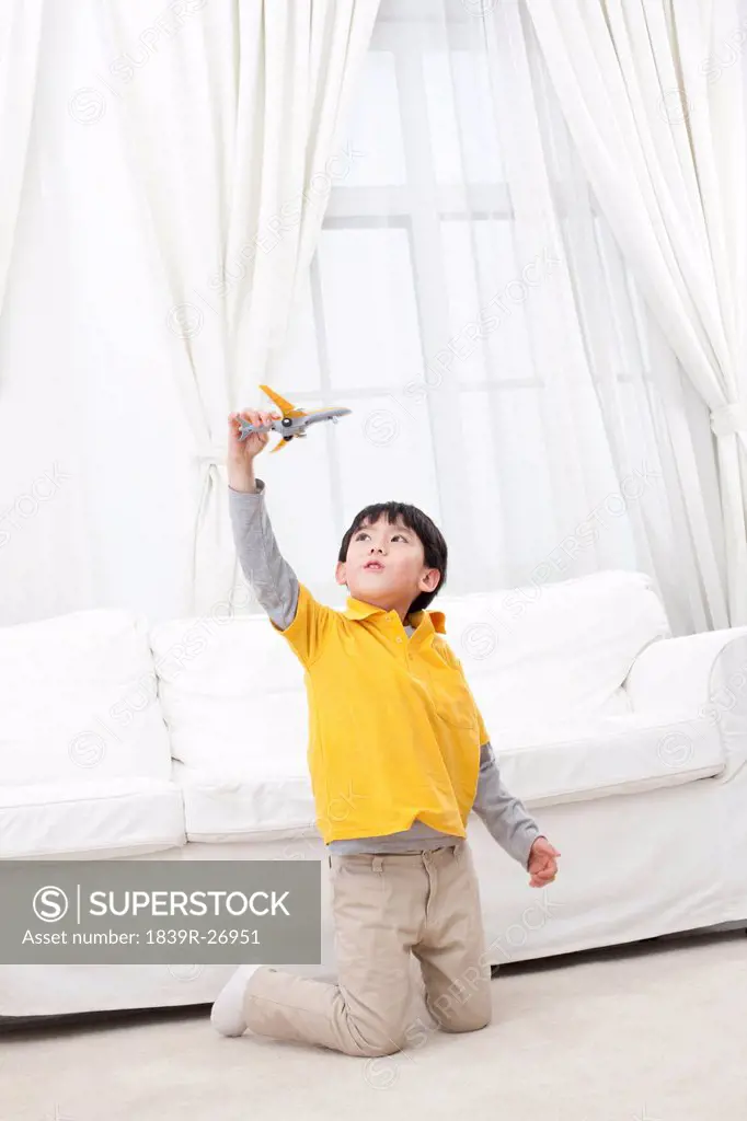 Little boy playing toy plane