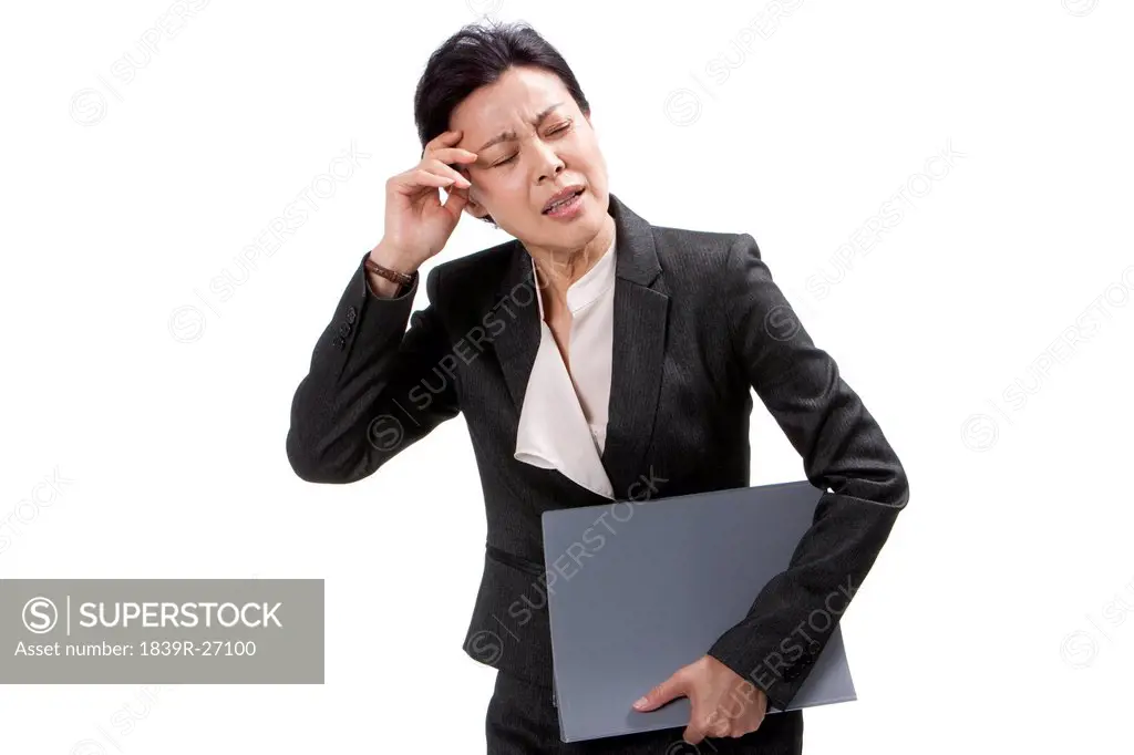 Middle_aged businesswoman suffering from headache