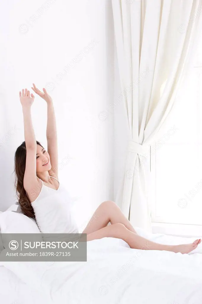 Young woman giving a stretch in bed