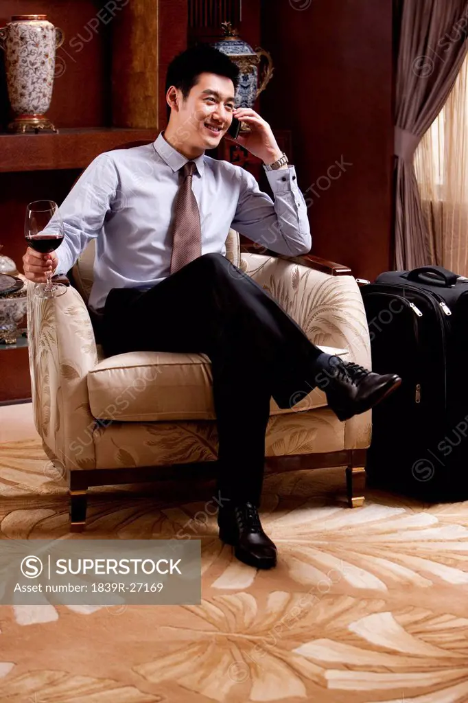 Young businessman using mobile phone in hotel
