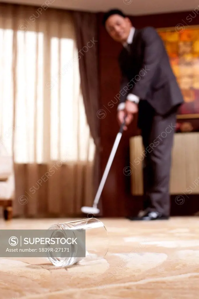 Mature businessman playing golf in a luxurious room