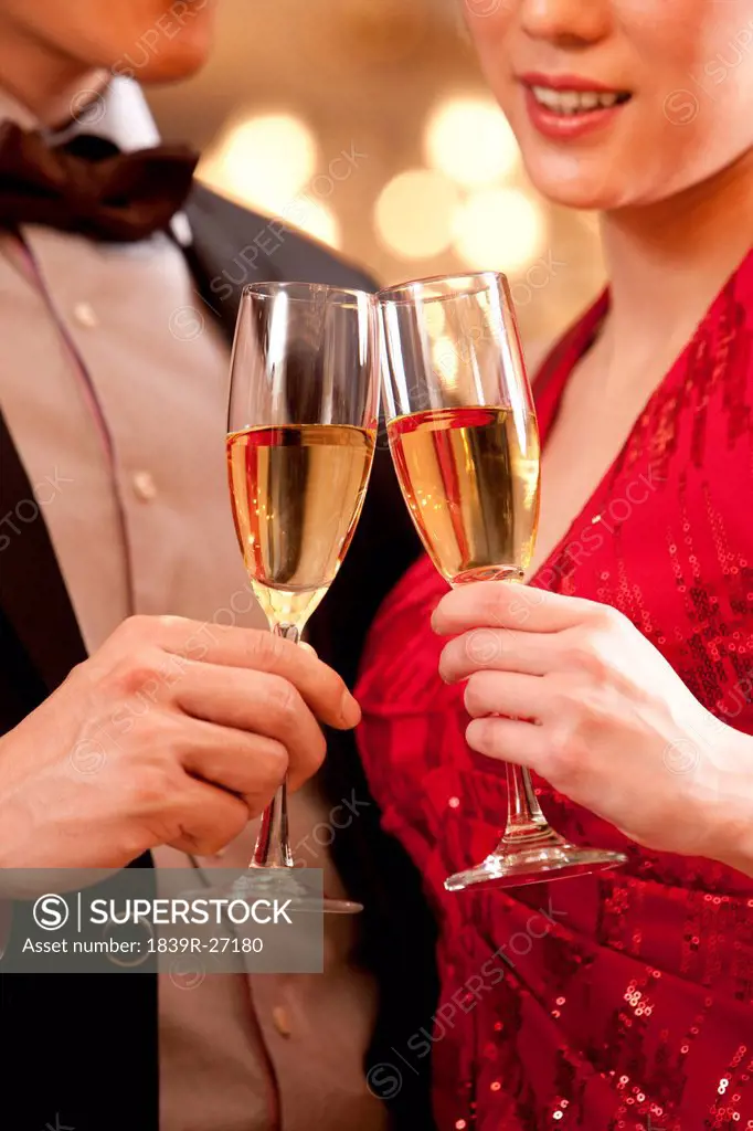 Young couple having champagne in a luxurious room