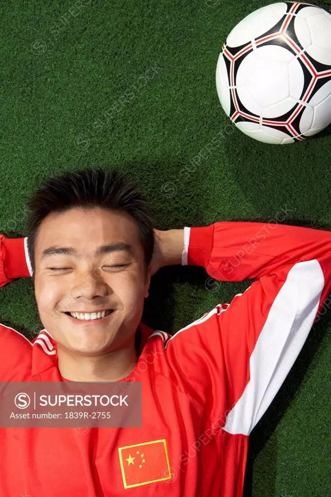 Chinese Soccer Player Lying On His Back Smiling