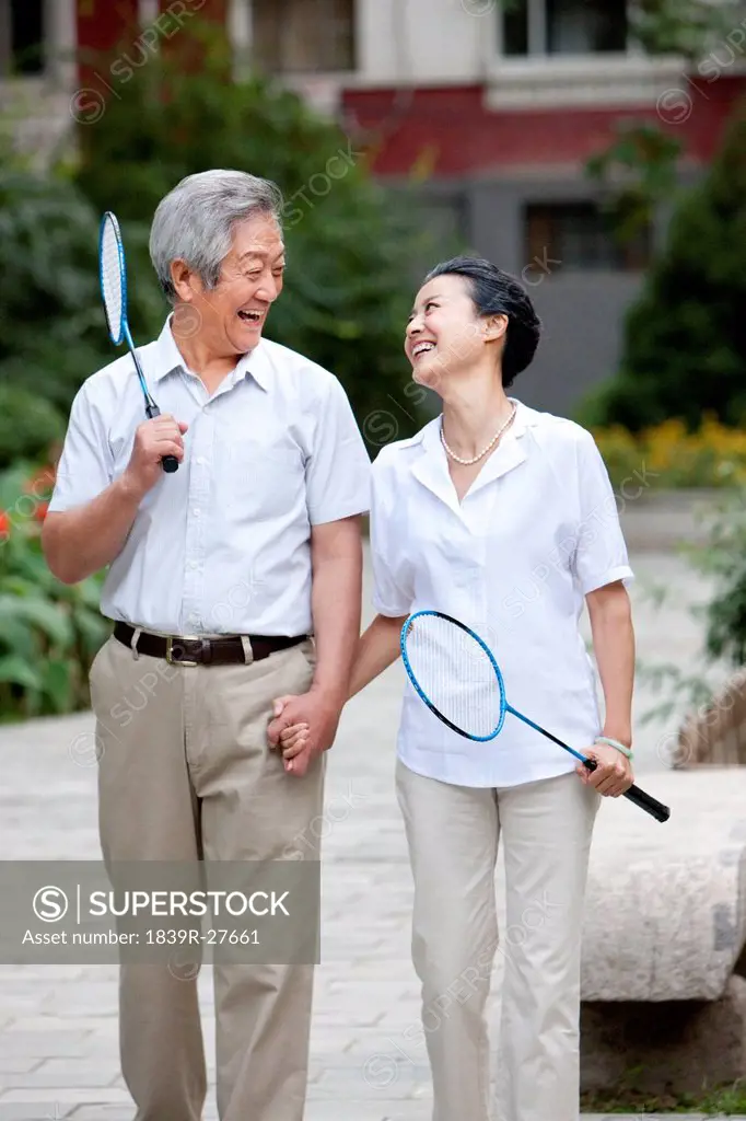 Senior couple holding badminton racket
