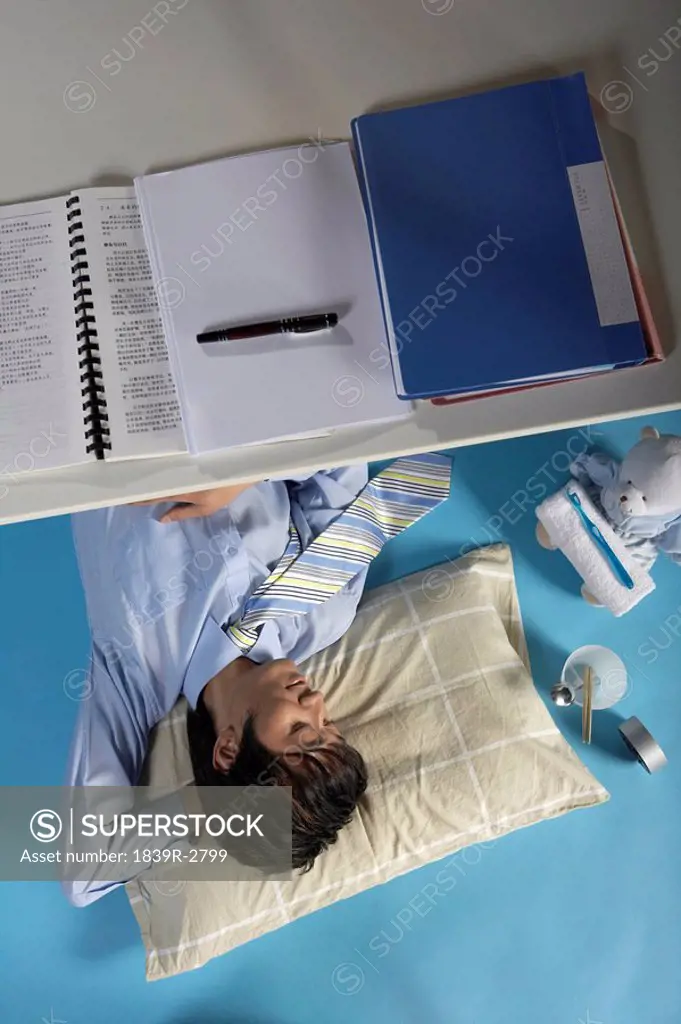 Man Sleeping Under His Desk