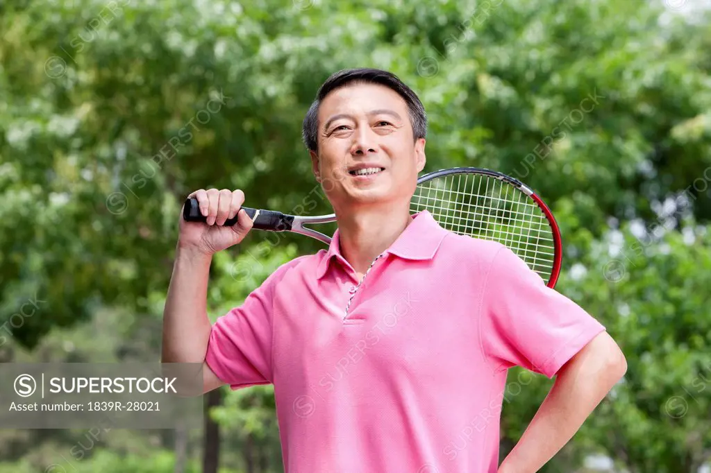 Senior man playing tennis in park