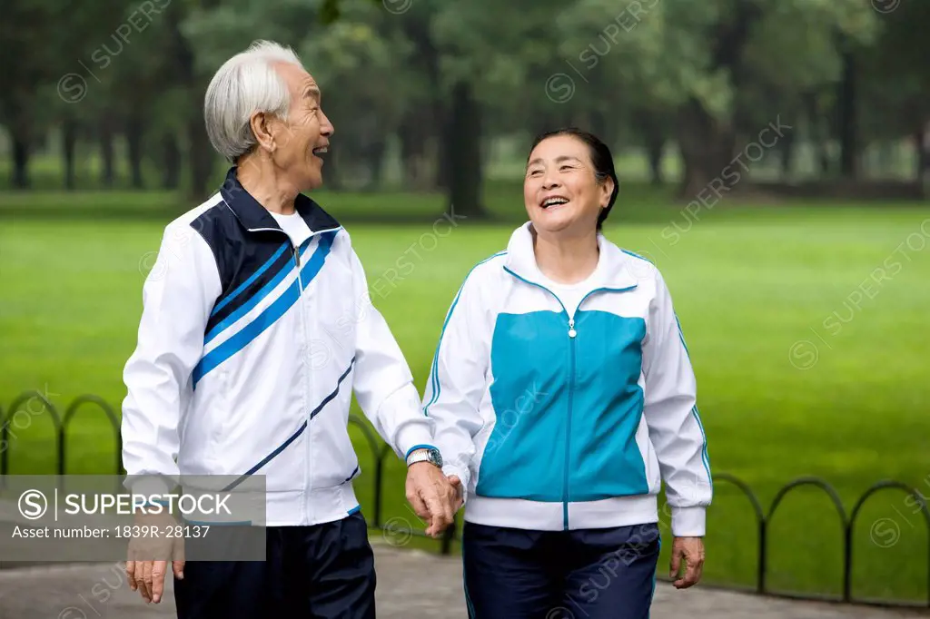 Senior Couple Walking Hand_In_Hand Through a Park