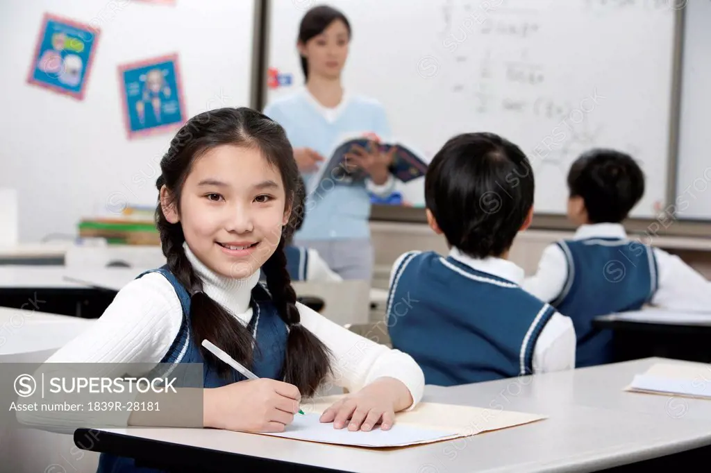 Young student sitting at her desk in the classroom