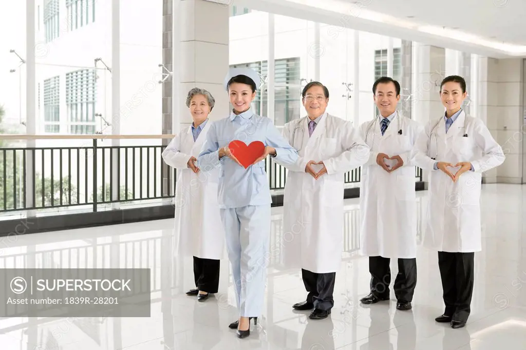 Four Doctors and One Nurse Making or Holding Heart Shapes