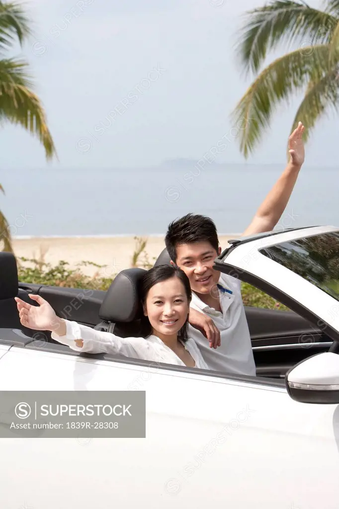 Happy Young Couple Posing in a Convertible